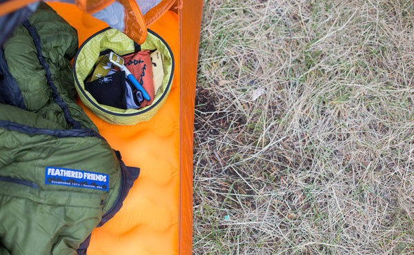 A Large Travel Tray holding keys, a facemask, a pen, and a few bandanas.